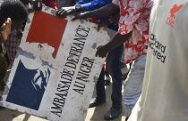 Protesters hold a sign taken from the French Embassy in Niamey during a demonstration that followed a rally in support of Niger's junta.