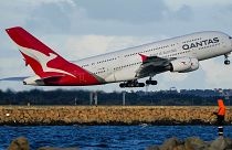 A Qantas A380 takes off from Sydney Airport over Botany Bay as a fisherman stands on breakwater in Sydney, Australia, Monday, Sept. 5, 2022.