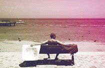 Un touriste est assis sur un banc à la plage de Finikoudes dans la ville côtière de Larnaca, mai 2022.