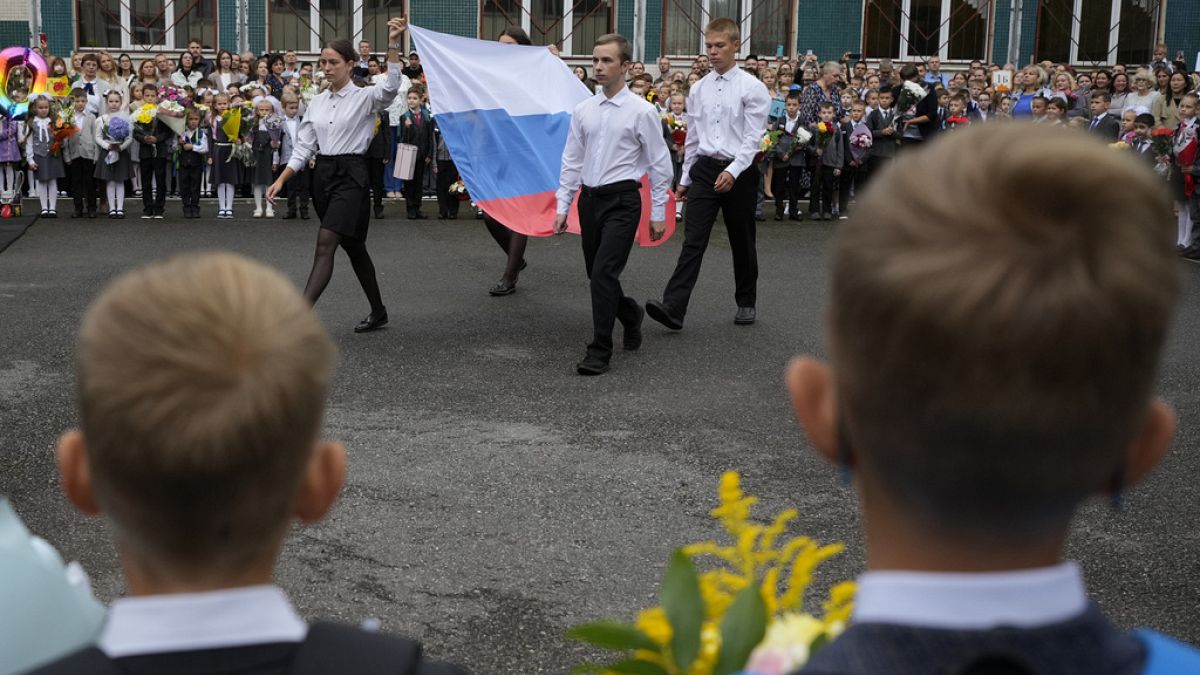 تلاميذ يحملون العلم الروسي خلال حفل بمناسبة بدء الفصول الدراسية في إحدى المدارس كجزء من الافتتاح التقليدي للعام الدراسي، في سانت بطرسبرغ، روسيا، الجمعة 1 سبتمبر 2023. 