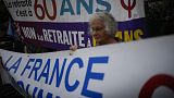 A nyugdíjreform ellen tüntető nő transzparenssel a 76. cannes-i filmfesztiválon 2023. május 21-én