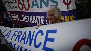 A nyugdíjreform ellen tüntető nő transzparenssel a 76. cannes-i filmfesztiválon 2023. május 21-én