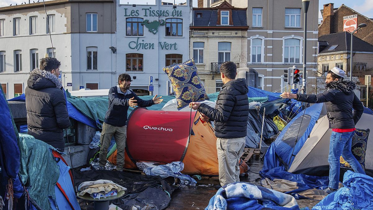 DOSYA - 17 Ocak 2023 tarihinde Brüksel'deki Petit Chateau kabul merkezinin dışında derme çatma bir çadır kampında erkekler eşyalarını düzenliyor. 