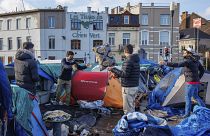 FILE - Men organise their belongings at a makeshift tent camp outside the Petit Chateau reception center in Brussels, on Jan. 17, 2023. 