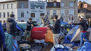 FILE - Men organise their belongings at a makeshift tent camp outside the Petit Chateau reception center in Brussels, on Jan. 17, 2023.