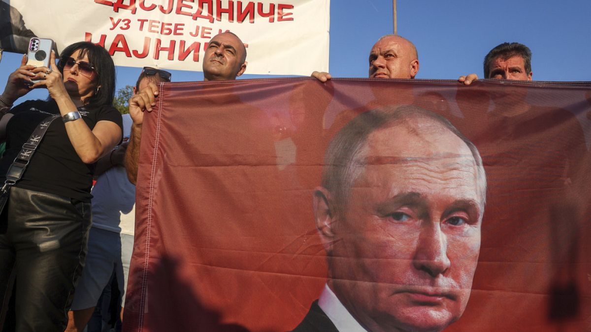 Protesters hold a flag showing Russian President Vladimir Putin during a rally supporting Milorad Dodik, pro-Russian leader in Bosnia, Lukavica, Bosnia, Friday, Sept. 1, 2023