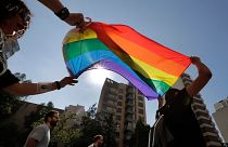 Activists from the LGBTQ+ community in Lebanon shout slogans and hold up a rainbow demanding rights during a protest in Beirut, 2020