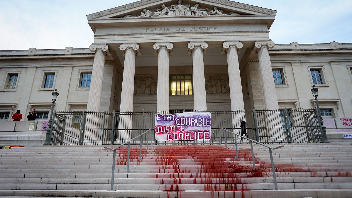 A protest at the Marseille courthouse features red dye representing the blood of victims of feminicide in March
