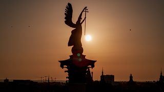 Budapesti látkép a felkelő nappal és a Hősök tere szoborcsoportjának tetejével