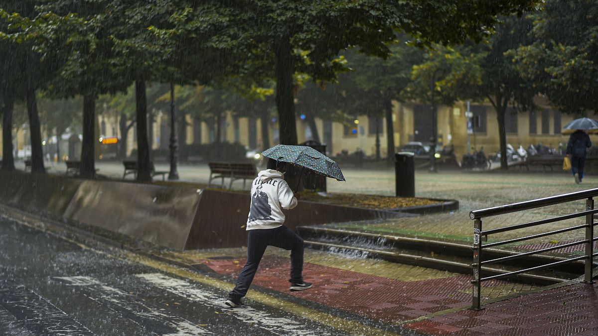Eső elől futó járókelő az észak-spanyolországi Pamplonában 2023. szeptember 2-án