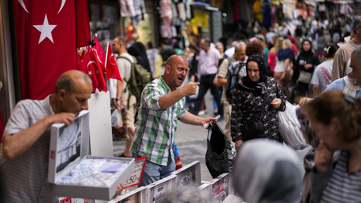 Des vendeurs s'occupent des clients dans un marché de rue dans le quartier commercial d'Eminonu à Istanbul, en Turquie, le vendredi 16 juin 2023.