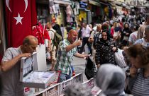 Venditori ambulanti assistono i clienti in un mercato di strada nel quartiere commerciale di Eminonu, a Istanbul, Turchia. (16 giugno 2023).