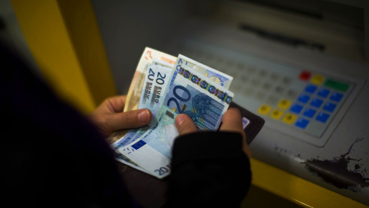 Клиент банка посчитывает купюры евро
