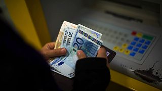 Клиент банка посчитывает купюры евро