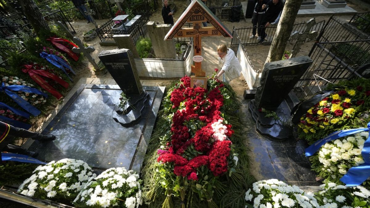 Женщина возлагает цветы на могилу главы группы компаний "Вагнер" Евгения Пригожина на Пороховском кладбище в Санкт-Петербурге, Россия, в среду, 30 августа 2023 года.