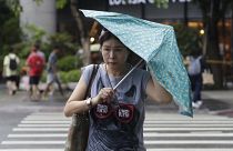امرأة تكافح بمظلتها ضد هبوب الرياح الناتجة عن إعصار هايكوي في تايوان
