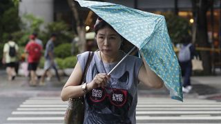 امرأة تكافح بمظلتها ضد هبوب الرياح الناتجة عن إعصار هايكوي في تايوان 