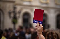 Eine Frau hält eine rote Karte hoch, während einer Solidaritätskundgebung mit Jennifer Hermoso
