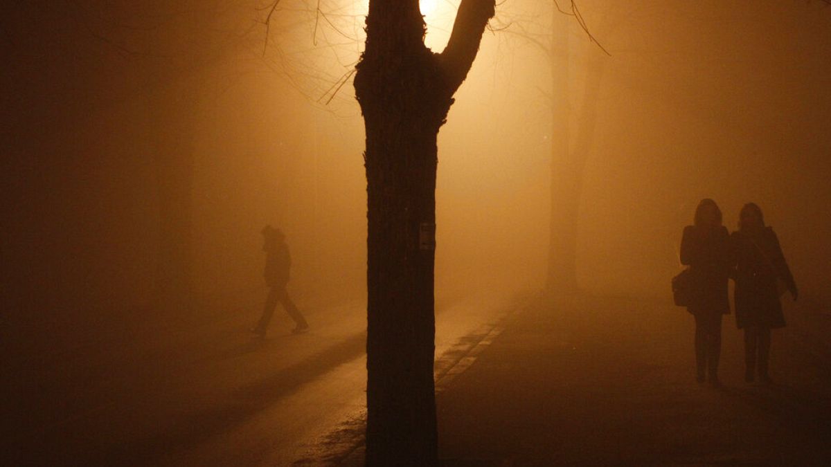 Bosnian people walking on the street during heavy smog in northern Bosnian town of Tuzla, 140 kms. north of Sarajevo, Monday, Dec. 16, 2013.