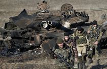 مقاتلون موالون لموسكو في الدونباس عام 2015 ووراءهم دبابة أوكرانية مدمرة 