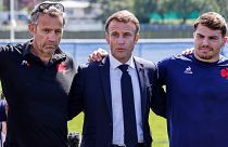 Le président français Emmanuel Macron, au centre, entouré de l'entraîneur Fabien Galthie, à gauche, et d'Antoine Dupont, à Rueil-Malmaison, lundi 4 septembre 2023.