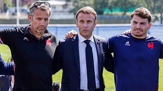 Le président français Emmanuel Macron, au centre, entouré de l'entraîneur Fabien Galthie, à gauche, et d'Antoine Dupont, à Rueil-Malmaison, lundi 4 septembre 2023.