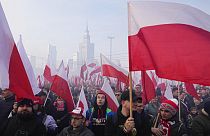 File - People hold Polish flags, during the annual Independence Day march in Warsaw, Poland, Thursday, Nov. 11, 2021. 