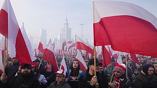 File - People hold Polish flags, during the annual Independence Day march in Warsaw, Poland, Thursday, Nov. 11, 2021.