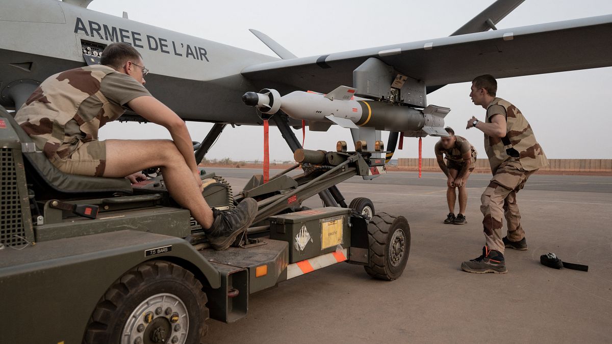 جنود فرنسيون يزيلون قنبلة موجهة بالليزر من طائرة بدون طيار في قاعدة BAP الجوية الفرنسية في نيامي