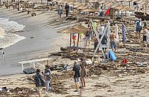 Menschen laufen zwischen zerstörten Gegenständen am Strand im bulgarischen Arapya nach den schweren Unwettern