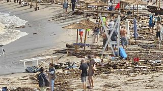 Menschen laufen zwischen zerstörten Gegenständen am Strand im bulgarischen Arapya nach den schweren Unwettern