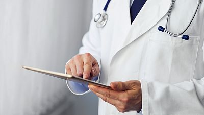 A doctor working with a digital tablet.