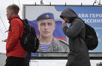Katonai propaganda Oroszországban: egy frontkatona portréja "dicsőség a hősöknek" felirattal.