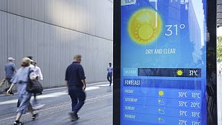 People walking past a weather report in Tower Bridge, London, England, Thursday Sept. 7, 2023