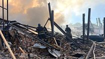 Emergency services personnel work to extinguish a fire following a Russian attack in Kryvyi Rih