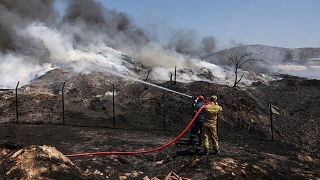I vigili del fuoco cercano di spegnere un incendio in un impianto di riciclaggio a Sesklo, nella Grecia centrale, il 26 luglio 2023\.
