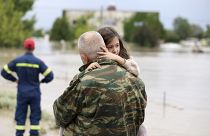 جندي في الجيش اليوناني يحمل طفلة أثناء عمليات البحث والإنقاذ