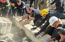 Сотрудники экстренных служб и полицейские вытаскивают раненого из-под завалов на месте российского ракетного удара, Кривой Рог, 8 сентября 2023 года.