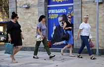 Women walk past a Russian Liberal Democratic Party poster with an image of former party leader Vladimir Zhirinovsky prior to local elections in Donetsk, eastern Ukraine.