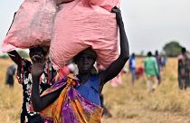 Locals in South Sudan collect the food drop of grain, delivered by the World Food Programme.