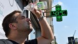A man pours water on himself during a heatwave in Turin, Italy, 25 August 2023.