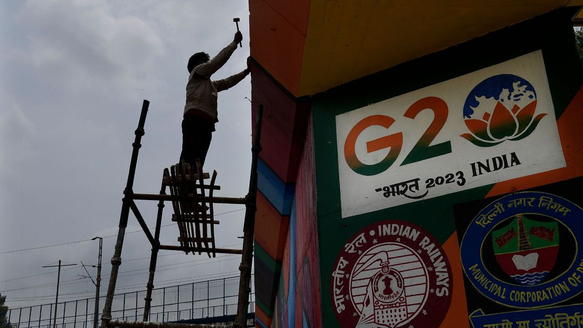 A worker paints an under-construction overhead bridge near the main venue of the G20 Summit, in New Delhi, India, Thursday, Aug. 24, 2023. 