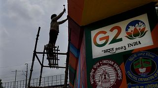 A worker paints an under-construction overhead bridge near the main venue of the G20 Summit, in New Delhi, India, Thursday, Aug. 24, 2023. 