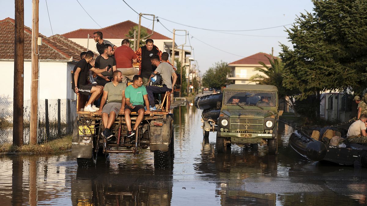 Local residents and members of the Greek army cross the flooded town of Palamas, near Karditsa, Thessaly region, central Greece, Friday, Sept. 8, 2023. 