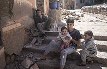A family sits outside their home after an earthquake in Moulay Ibrahim village, near Marrakech, Morocco, Saturday, Sept. 9, 2023.
