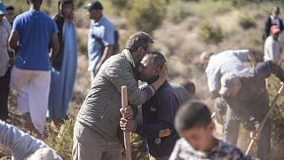 People comfort each other while digging graves for victims of the earthquake, in Ouargane village, near Marrakech, Morocco, Saturday, Sept. 9, 2023.