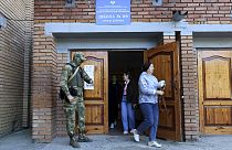 A serviceman guards an entrance of a polling station during a local elections in Donetsk, the capital of Russian-controlled Donetsk region, eastern Ukraine, on Sept. 10, 2023.