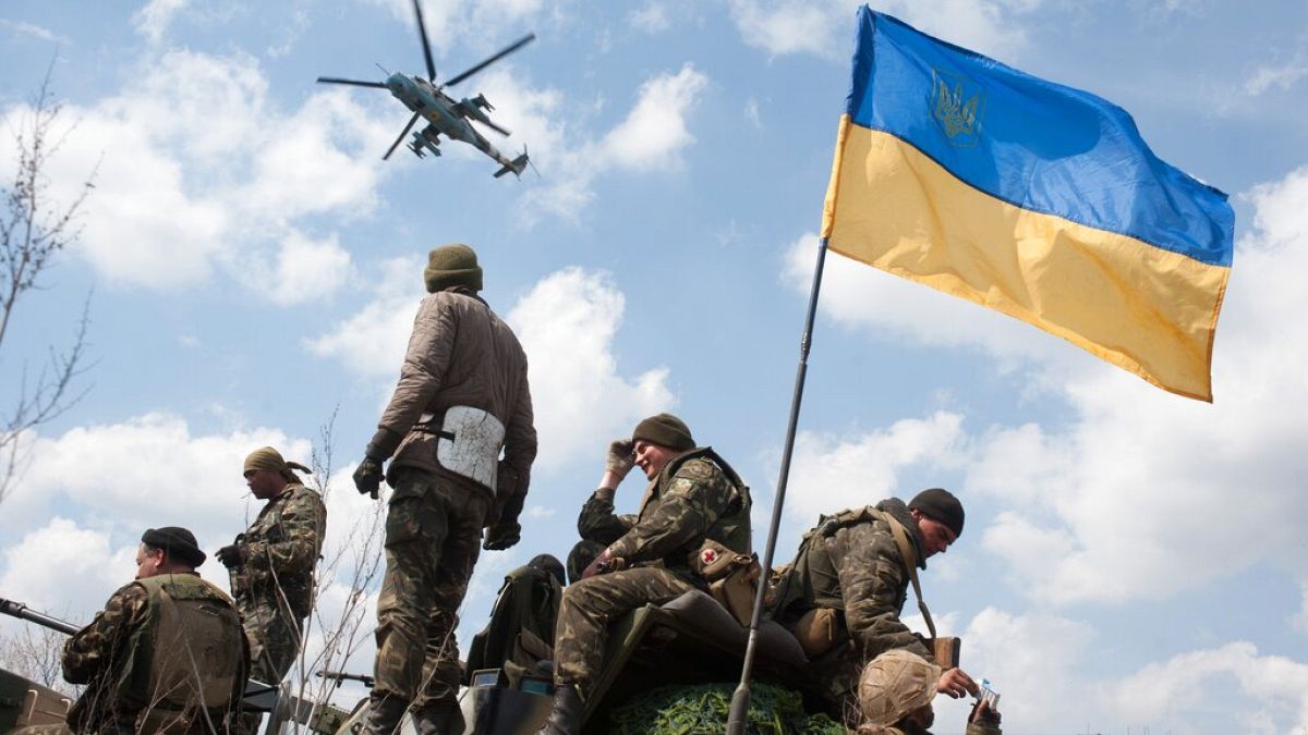 A Ukrainian Army helicopter flies over a column of Ukrainian Army combat vehicles on the way to the town of Kramatorsk.