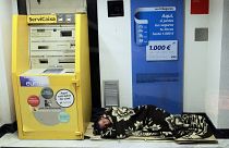 رجل نائم بالقرب من الصراف الآلي في وسط مدينة مدريد، إسبانيا.