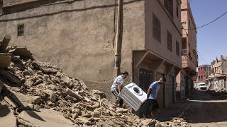 Egy mosógépet hoznak ki a romok közül a földrengés sújtotta térségben